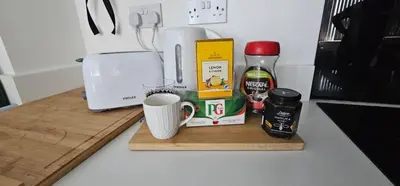 a counter with a coffee maker and a cup on a cutting board at 2 Bedroom Apartment with Amazing Views of Liverpool City Centre in Liverpool