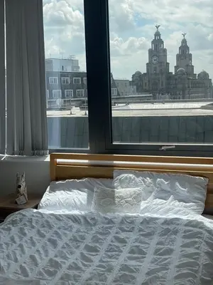 a bed in a bedroom with a large window at 2 Bedroom Apartment with Amazing Views of Liverpool City Centre in Liverpool