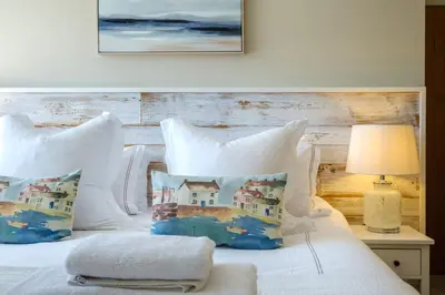 a bedroom with a bed with white sheets and pillows at The Bolt Hole in Silverdale