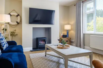 a living room with a blue couch and a table at The Bolt Hole in Silverdale
