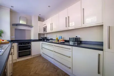 a kitchen with white cabinets and black counter tops at The Bolt Hole in Silverdale