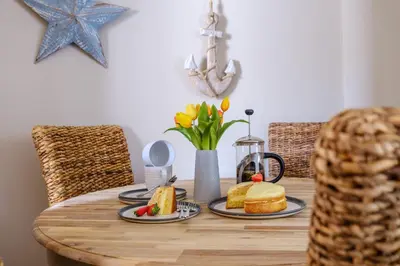 a wooden table with food and flowers on it at The Bolt Hole in Silverdale