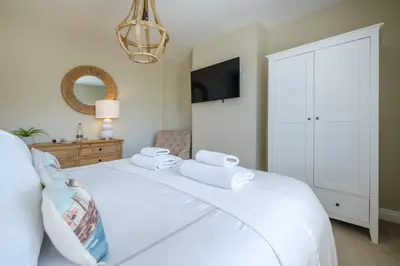 a bedroom with a white bed with towels on it at The Bolt Hole in Silverdale