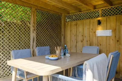 a wooden table with chairs and a bowl of food on it at The Bolt Hole in Silverdale