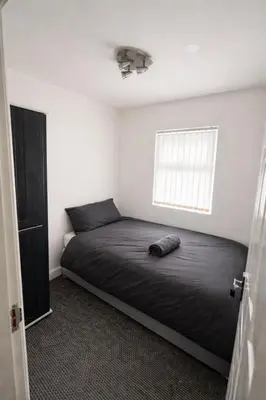 a bedroom with a bed in a room with a window at Affordable room near Anfield stadium - 5 minute walk in Liverpool