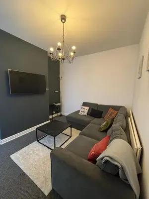 a living room with a couch and a flat screen tv at Affordable room near Anfield stadium - 5 minute walk in Liverpool