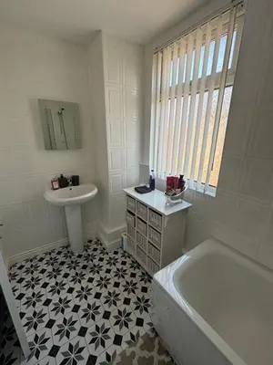 a white bathroom with a sink and a tub and a sink at Affordable room near Anfield stadium - 5 minute walk in Liverpool