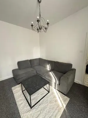 a living room with a couch and a table at Affordable room near Anfield stadium - 5 minute walk in Liverpool