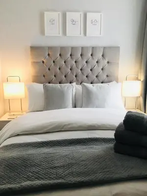 a bedroom with a large white bed with two lamps at Chadberry House Hotel in Blackpool