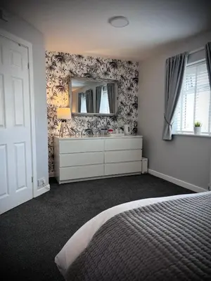 a bedroom with a bed and a dresser and a mirror at Chadberry House Hotel in Blackpool