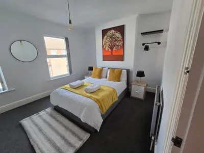 a bedroom with a large bed with a yellow blanket at Room 3 Shared house in Kensington in Liverpool