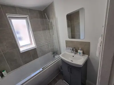 a bathroom with a sink and a toilet and a tub and a mirror at Room 3 Shared house in Kensington in Liverpool