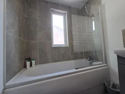a bathroom with a bath tub and a window at Room 3 Shared house in Kensington in Liverpool