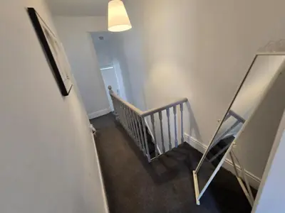a hallway with a stairway with a mirror and a stair case at Room 3 Shared house in Kensington in Liverpool