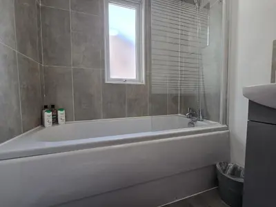 a white bath tub in a bathroom with a window at Room 3 Shared house in Kensington in Liverpool
