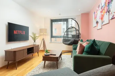 a living room with a green couch and a tv at Central Town Retreat Modern 2BR2BA Apartment Sleeps 7 in Liverpool