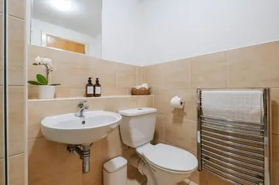 a bathroom with a toilet and a sink at Central Town Retreat Modern 2BR2BA Apartment Sleeps 7 in Liverpool