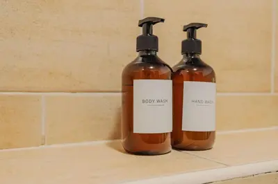two bottles of soap on a shelf in a bathroom at Central Town Retreat Modern 2BR2BA Apartment Sleeps 7 in Liverpool
