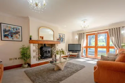 a living room with a fireplace and a television at Pendle View Gatehouse Lakeside Stay in Pendleton