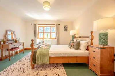 a bedroom with a bed and a dresser and a window at Pendle View Gatehouse Lakeside Stay in Pendleton