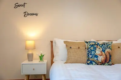 a bedroom with a bed and a table with a lamp at Pendle View Gatehouse Lakeside Stay in Pendleton