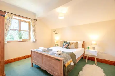 a bedroom with a large bed and a window at Pendle View Gatehouse Lakeside Stay in Pendleton