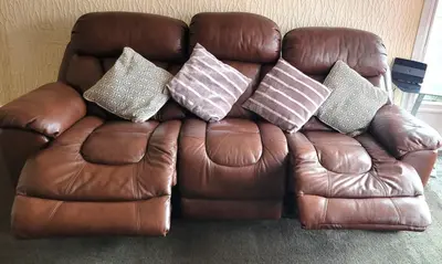 a brown leather couch with four pillows on it at Stylish and Spacious two-bedroom Apartment in Blackpool