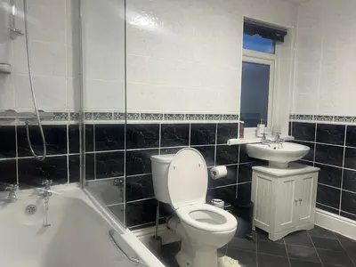 a bathroom with a toilet and a sink and a tub at Stylish and Spacious two-bedroom Apartment in Blackpool