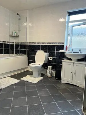 a bathroom with a toilet and a tub and a sink at Stylish and Spacious two-bedroom Apartment in Blackpool