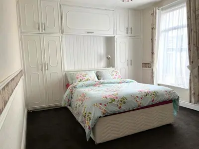 a white bedroom with a bed and a large window at Stylish and Spacious two-bedroom Apartment in Blackpool