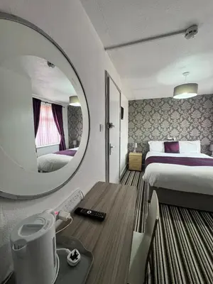 a hotel room with a bed and a mirror at On The Beach Hotel in Blackpool