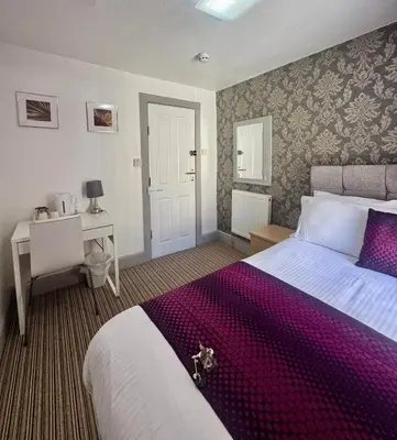 a hotel room with a bed and a desk and a bed sidx sidx at On The Beach Hotel in Blackpool