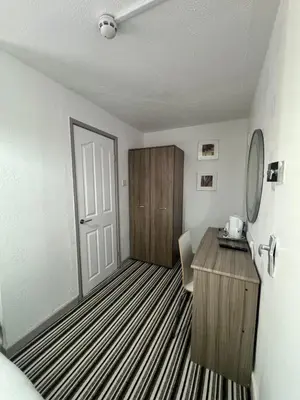 a room with a wooden desk and a door at On The Beach Hotel in Blackpool