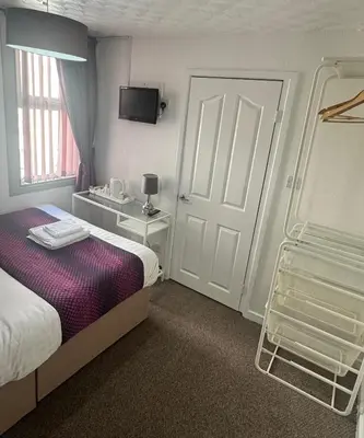a hotel room with a bed and a tv at On The Beach Hotel in Blackpool