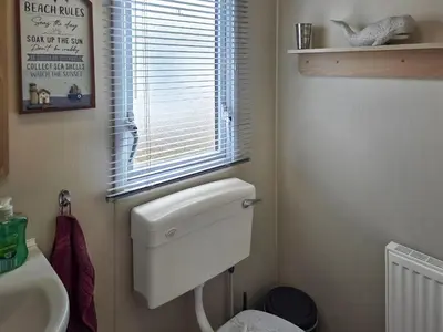 a bathroom with a white toilet and a window at Waterlily in Lancaster