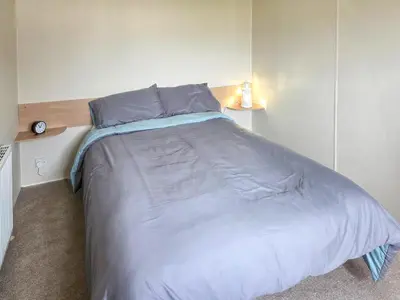 a bedroom with a large bed with blue sheets at Waterlily in Lancaster