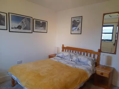a bedroom with a bed and a mirror on the wall at Double room, living space and bathroom, in a family home, near Ulverston in Pennington