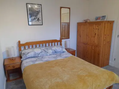 a bedroom with a bed and a dresser and a mirror at Double room, living space and bathroom, in a family home, near Ulverston in Pennington