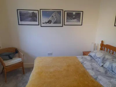 a bedroom with a bed and three pictures on the wall at Double room, living space and bathroom, in a family home, near Ulverston in Pennington