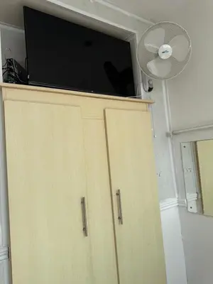 a television on top of a cabinet with a fan at Lynton apartments in Blackpool