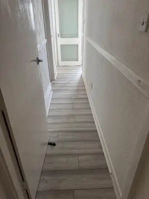 an empty hallway with an open door and a hallwayngth at Lynton apartments in Blackpool