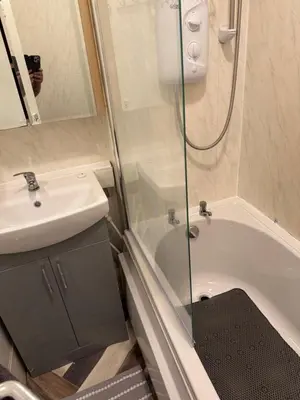 a bathroom with a shower and a sink and a tub at Lynton apartments in Blackpool