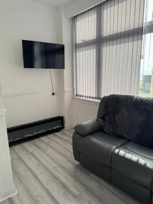 a living room with a couch and a flat screen tv at Lynton apartments in Blackpool