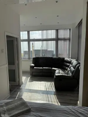 a couch in a living room with a large window at Lynton apartments in Blackpool