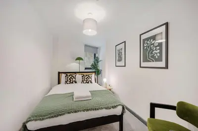 a bedroom with a bed with a green blanket at Baltic Apt II - City Centre with Parking, Sleeps 6 in Liverpool