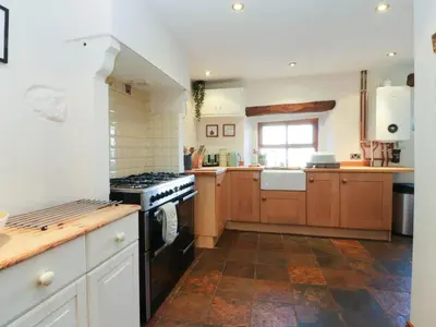 a kitchen with wooden cabinets and a stove top oven at Sunnybrook Cottage in Lancaster