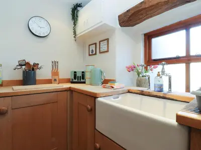 a kitchen with a sink and a clock on the wall at Sunnybrook Cottage in Lancaster