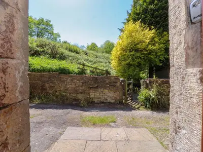 an entrance to a garden with a stone wall at Sunnybrook Cottage in Lancaster