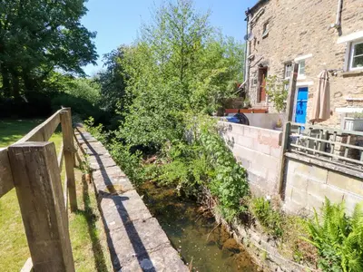 a canal in front of a building with a fence at Sunnybrook Cottage in Lancaster