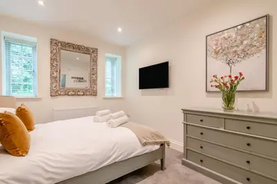 a bedroom with a bed with a dresser and a mirror at 3 Bed in West Bradford oc-g32102 in West Bradford